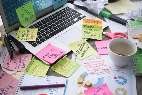 Notebook computer and desk covered in sticky notes