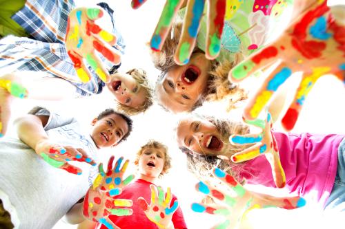 Дети с разноцветными красками на ладошках