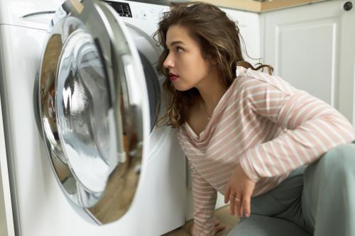Женщина перед стиральной машиной